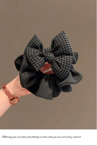 Détail d'un chouchou à carreaux gris montrant la texture et le design du gros nœud