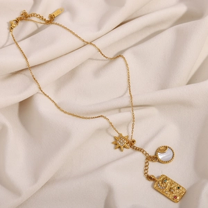 Close-up of 18K gold plated necklace with star charm and tarot card style rectangle pendant