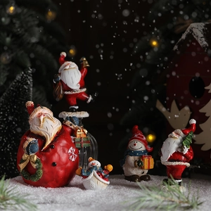 Resin Santa and Snowman figurines set on snow with warm bokeh Christmas lights
