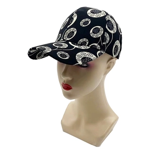 Detail of black baseball cap featuring white clover floral embroidery on twill cotton fabric