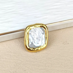 Detailed view of large natural freshwater pearl set in a gold plated square metal frame