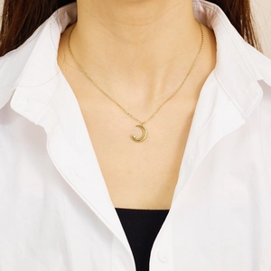 Détail macro du collier pendentif lune plaqué or 18k avec zircon blanc sur mannequin