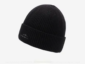 Side view of black ribbed knit beanie featuring detailed mountain peak embroidery