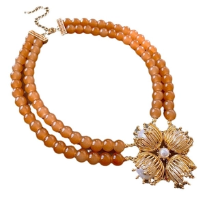 Elegant double-layer orange beaded necklace featuring a large gold floral pendant with pearls