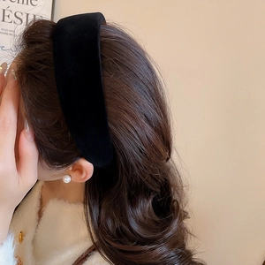 Detail view of black velvet headband on model showing soft texture and high top design