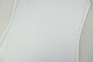 Detail showing the white knitted fabric texture and pleated pleats of the sleeveless dress