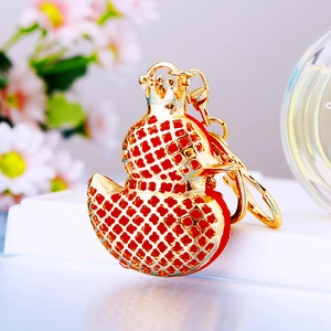 Close-up of golden duck keychain with crown and sparkling red rhinestone mesh pattern