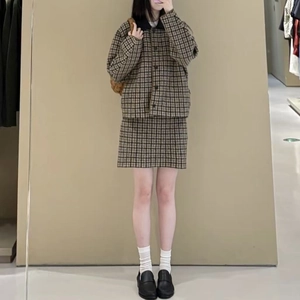 Selfie allo specchio di un blazer scozzese vintage con minigonna coordinata marrone