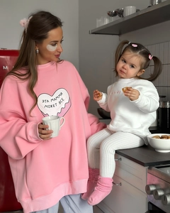 Gros plan de sweat-shirts à imprimé cœur rose et blanc avec texte russe dans une cuisine