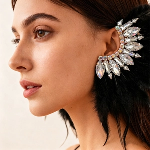 Detailed close-up of a luxury ear cuff with iridescent crystals and soft black feathers