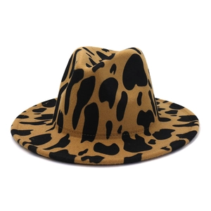 Close-up of the fedora hat featuring a brown cow print pattern and wide flat brim
