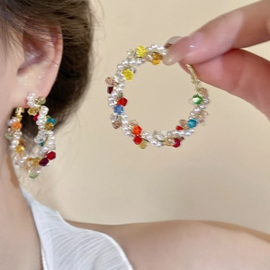 Boucles d'oreilles créoles faites à la main avec perles et cristaux colorés sur modèle