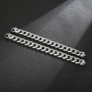 Polished stainless steel Cuban chain bracelets on a textured dark background