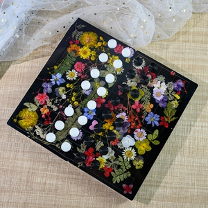 Vue de dessus d'un échiquier en résine avec fleurs séchées et pièces à texture en spirale