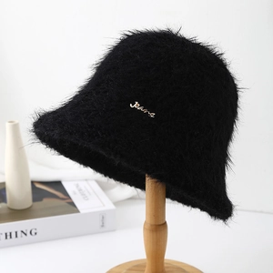 Vue détaillée du chapeau bob en peluche noire avec logo en métal doré