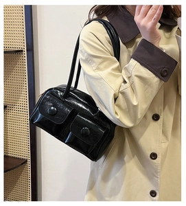 Side view of model wearing a glossy black multi-pocket shoulder bag with twin straps