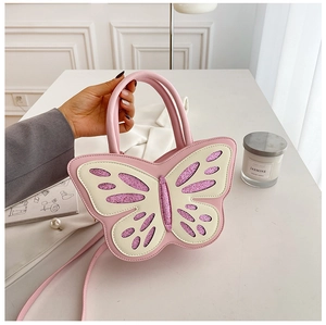 Detail of butterfly-shaped pink PU leather bag with cream wings and shimmering sequins
