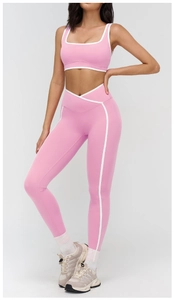 Detail of pink yoga set featuring white piping and V-shape high waist leggings