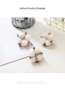 Close-up of three natural dried cotton flower heads in a golden basket for home decor
