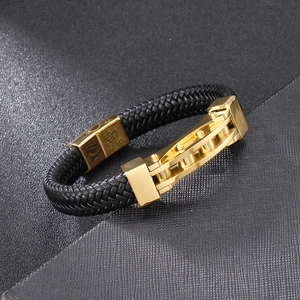 Detail of black braided leather bracelet with golden industrial chain link decor