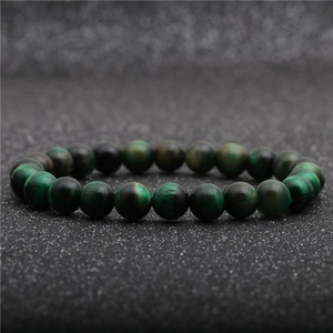 Macro detail of natural green tiger eye bracelet beads with cat-eye effect shimmer