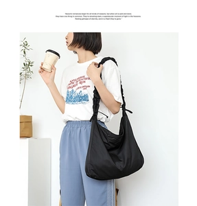 Macro view of pleated shoulder strap and black nylon texture on casual shoulder bag