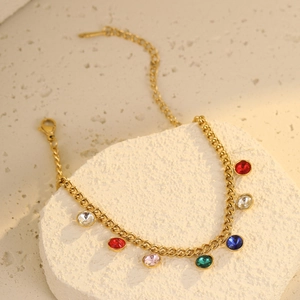 Macro shot of gold bracelet with colorful round gemstones and fine chain details