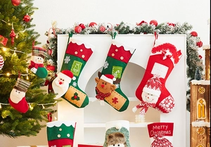 Detail of plush Christmas stockings with 3D Santa and Reindeer hanging on a fireplace
