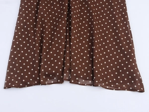 Détail de la robe vintage en mousseline marron à pois blancs avec ourlet délicat