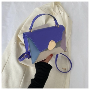 Détail du sac à main tricolore avec boucle dorée ovale et texture en cuir moderne