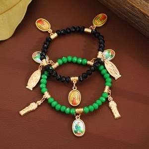 Vintage Virgin Mary beaded bracelet with black and green crystals on leather background