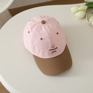 Close-up of pink and brown baseball cap with embroidered smiley face and Thank You text