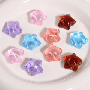 Close-up of colorful translucent resin star charms in a white ceramic bowl for DIY crafts