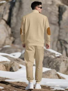 Rear view of men's beige knitted tracksuit with brown elbow patches in outdoor mountain setting