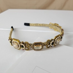 Detail of baroque gold headband with champagne crystals and pearls on white card