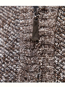 Detailed macro view of the mixed brown knit texture and half-zip collar of the sweater