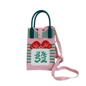 Pink knitted shoulder bag with green handle and red bow featuring a lucky Chinese character