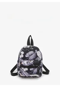 Detail of floral canvas backpack featuring purple flowers and adjustable black straps