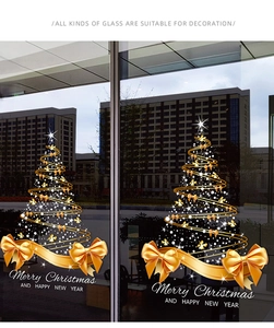 Golden Christmas tree glass sticker with bow and stars detail on shop window decoration