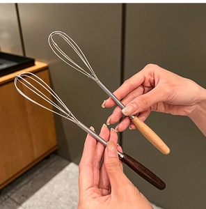Detail of manual whisks with dark and light wood handles and stainless steel wires