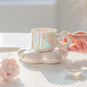Macro shot of a pearl white ceramic sunflower coffee cup with matching floral saucer set