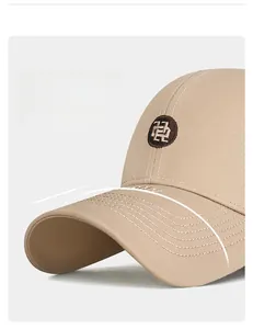 Detail of khaki cotton baseball cap with round embroidered patch and wide curved brim