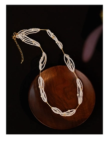 Close-up of vintage multi-strand pearl necklace with golden metal tubes and lobster clasp