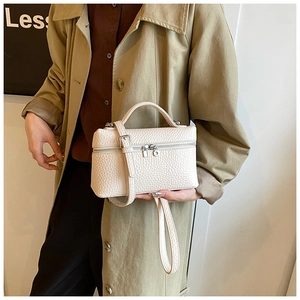 Detail of white lychee pattern leather box bag featuring double zipper and hand strap