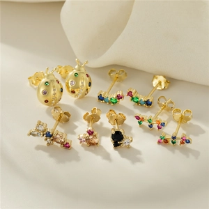 Detailed close-up of 7 gold-plated stud earrings with colorful zircon and ladybug designs