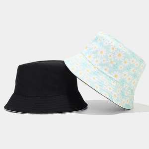 Close-up of mint green floral daisy pattern and black cotton sun hat textures