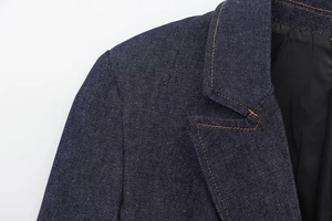 Close-up of deep blue denim blazer showing shoulder detail and contrast stitching texture