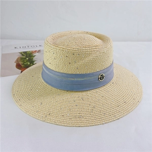Detail of straw sun hat featuring a light beige weave and blue band with T-shaped logo