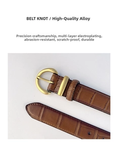 Detail of vintage brown crocodile embossed leather belt with gold alloy buckle