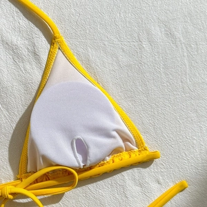 Detail of bright yellow bikini top showing interior lining and removable padding slots
